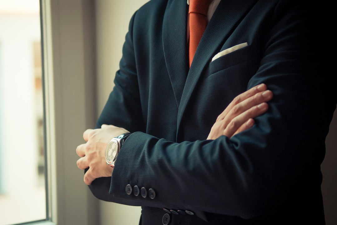 Mand i mørkt navy jakkesæt fra SUITS COPENHAGEN med armbåndsur, klar til en professionel arbejdsdag